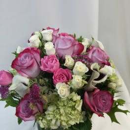 Bouquet of pink and white roses with calla lilies in a glass vase