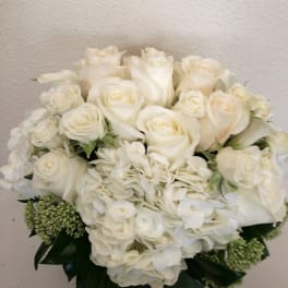 White roses and hydrangeas arranged in a low vase