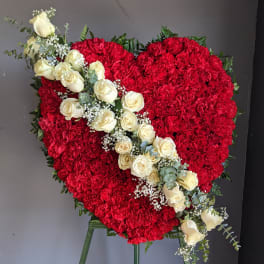 Heart-shaped red floral arrangement with a diagonal spray of white roses