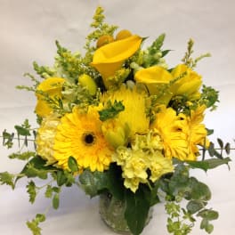 Yellow floral arrangement in a clear glass vase