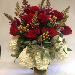 Bouquet of red roses and white hydrangeas in a burlap-wrapped vase