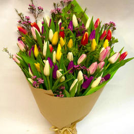 Bouquet of multicolored tulips wrapped in brown paper