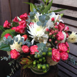 Bouquet of pink roses and white lilies in a vase with eucalyptus