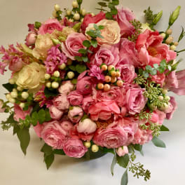 Round bouquet of pink and cream flowers with berries and greenery