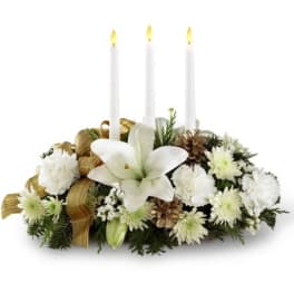 White floral centerpiece with three lit taper candles