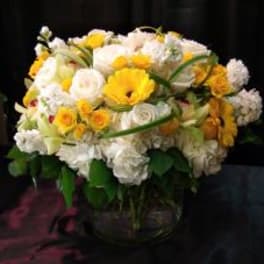 Yellow and white mixed flower arrangement in a glass vase