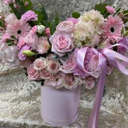 Pink roses and gerbera daisies in a lavender hatbox with ribbon