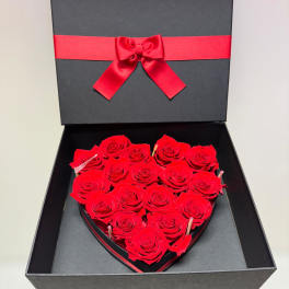 Heart-shaped box of red roses with a red ribbon bow