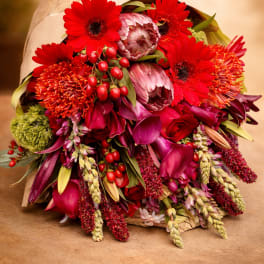 Bouquet of red and pink flowers wrapped in brown paper