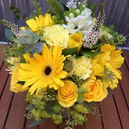Yellow bouquet with gerbera daisies and roses in a low arrangement