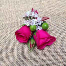 Two pink rose buds with small white filler flowers and green berries