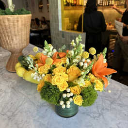 Yellow rose arrangement with orange lilies in a green vase