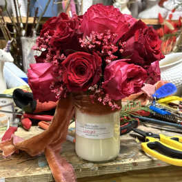 Bouquet of red and pink roses in a glass jar vase