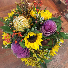 Mixed bouquet with sunflowers, purple ornamental cabbage, and berry accents