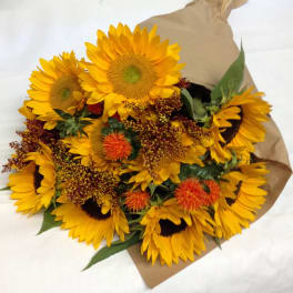 Bouquet of yellow sunflowers wrapped in brown paper