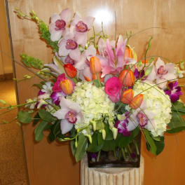 Mixed bouquet with orchids, tulips, hydrangeas, and roses in a vase