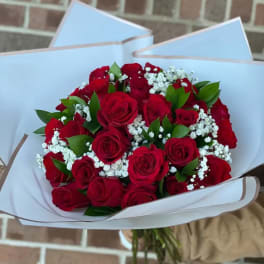 Bouquet of red roses with white baby's breath in white wrapping