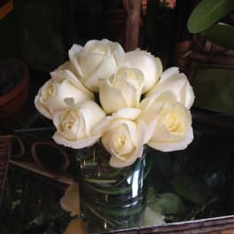 White roses arranged in a clear glass vase
