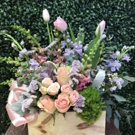 Pastel bouquet with pink roses and tulips in a wooden box
