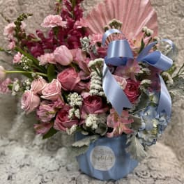 Pink roses and mixed flowers in a blue box with a ribbon