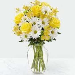 Yellow roses and white daisies in a clear glass vase