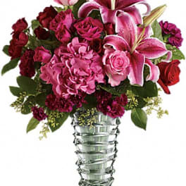 Pink and red floral arrangement in a clear glass vase