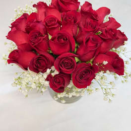 Bouquet of red roses with white baby's breath in a clear vase