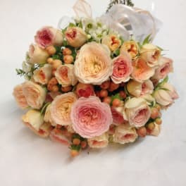Bouquet of blush and peach roses with small white flowers
