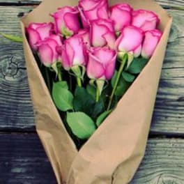 Bouquet of pink roses wrapped in brown paper