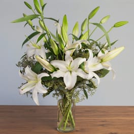 White lilies arranged in a clear glass vase