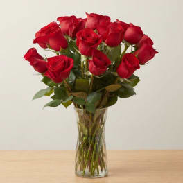 Red roses arranged in a clear glass vase