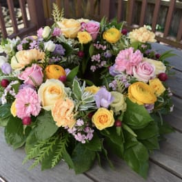 Colorful floral wreath with roses, carnations, and small filler flowers