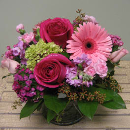 Pink and magenta flower arrangement in a glass vase