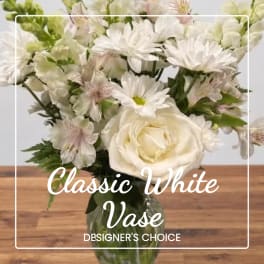 White floral bouquet in a glass vase with mixed blooms