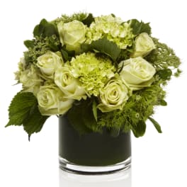 White roses and green hydrangeas in a glass vase