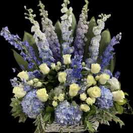 Blue and white floral arrangement in a white basket