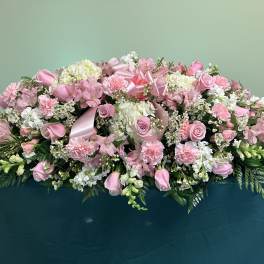 Large pink and white floral arrangement with ribbon accents
