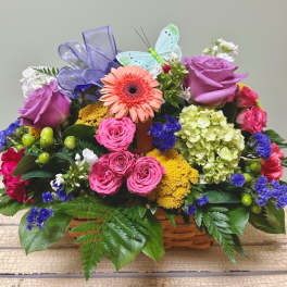 Colorful flower basket with roses, gerbera daisy, and ribbon butterfly