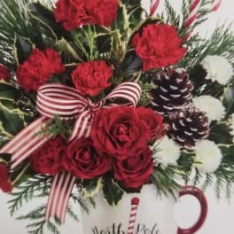 Red roses and carnations in a white mug with candy cane accents
