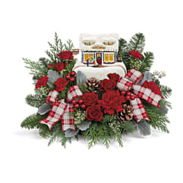 Christmas floral arrangement with red roses, plaid ribbons, and a small house ornament