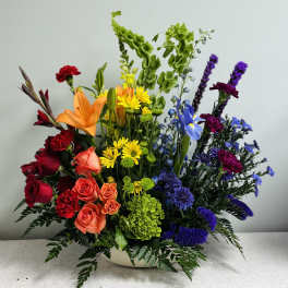 Colorful mixed flower arrangement in a low white bowl