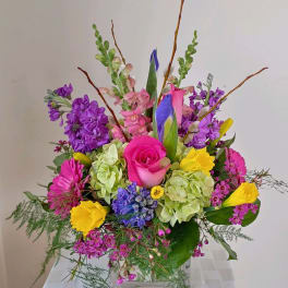 Colorful mixed flower arrangement in a clear glass vase