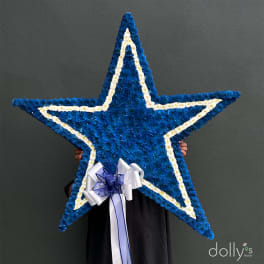 Blue and white star-shaped floral tribute with a ribbon bow