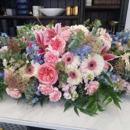 Large pastel floral arrangement with pink and white blooms and blue accents