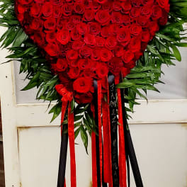 Heart-shaped red rose standing spray with red and black ribbons
