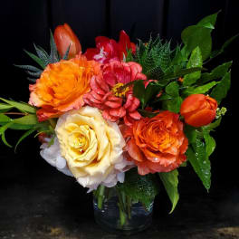 Colorful bouquet of roses and tulips in a clear glass vase