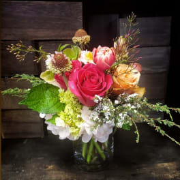 Mixed bouquet of pink and peach roses in a glass vase
