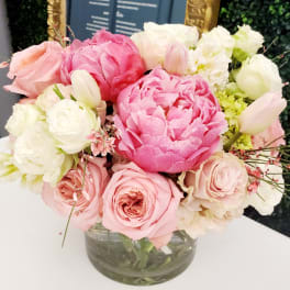 Pink and white bouquet of roses and peonies in a glass vase
