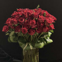 Bouquet of red roses in a tall glass vase