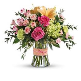 Bouquet of pink and yellow flowers in a glass vase